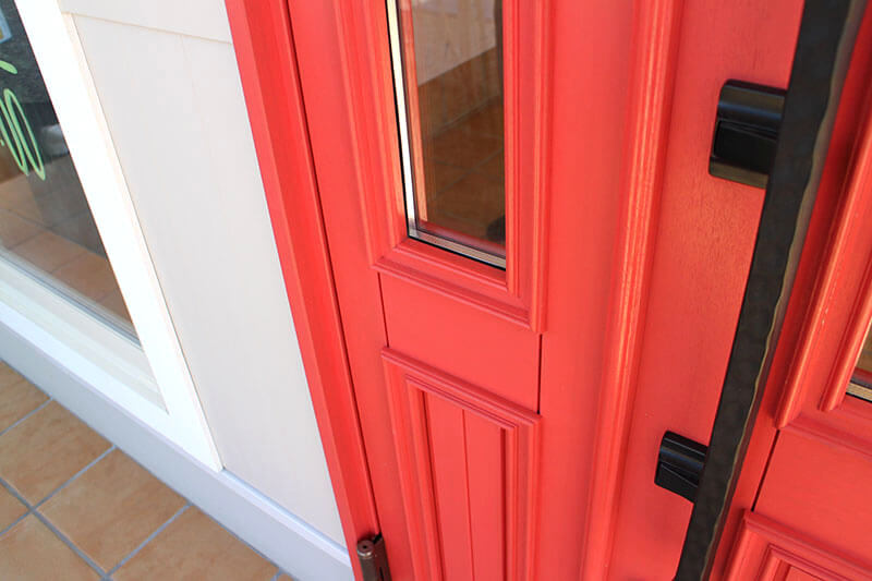トマト色塗りつぶしの木製玄関ドア