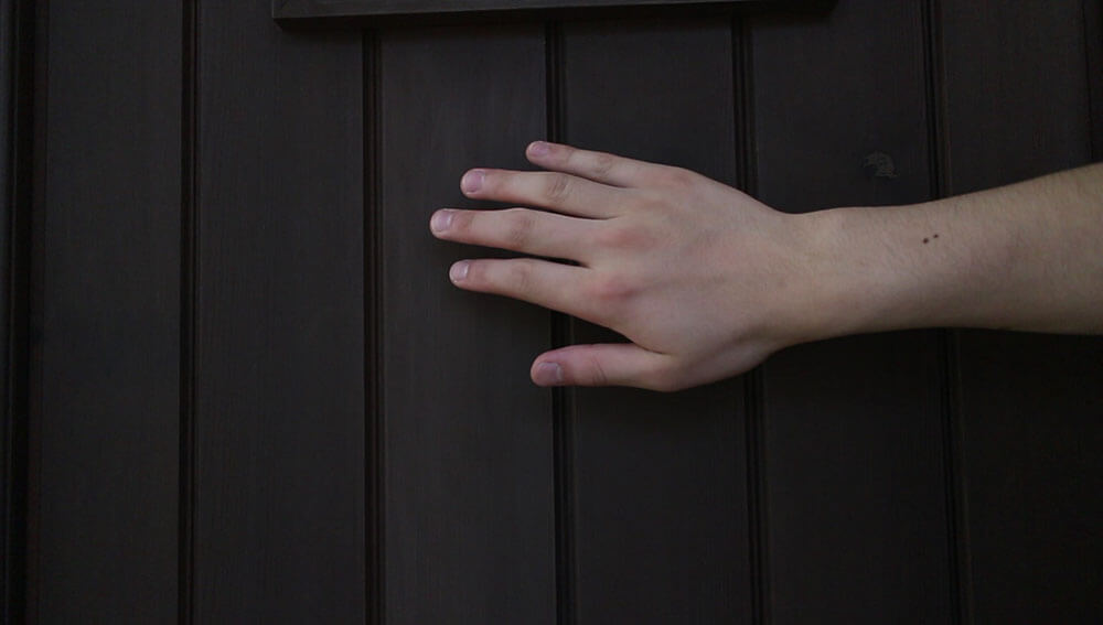 触って感触を確かめる-木製玄関ドアのメンテナンス再塗装